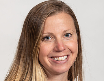 A woman with long blonde hair smiles for the camera.