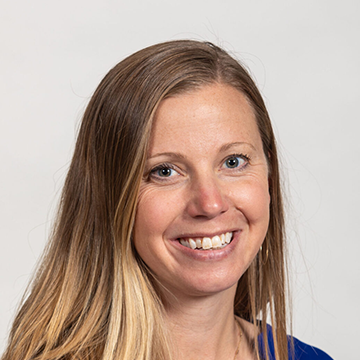 A woman with long blonde hair smiles for the camera.