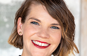 A woman with short brown hair and red lipstick.