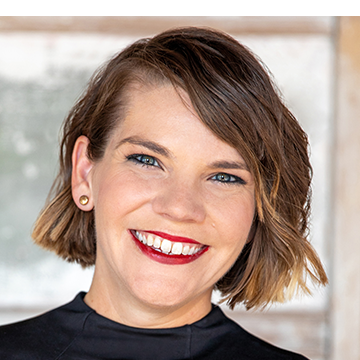 A woman with short brown hair and red lipstick.