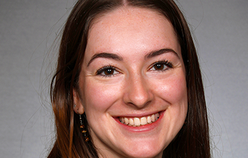 A woman with long brown hair smiles for the camera.