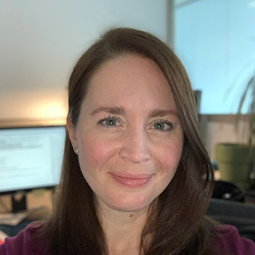 A woman with long hair and wearing a purple shirt.