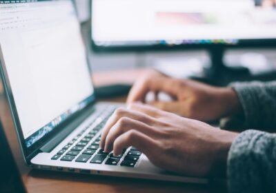 A person typing on a laptop computer.