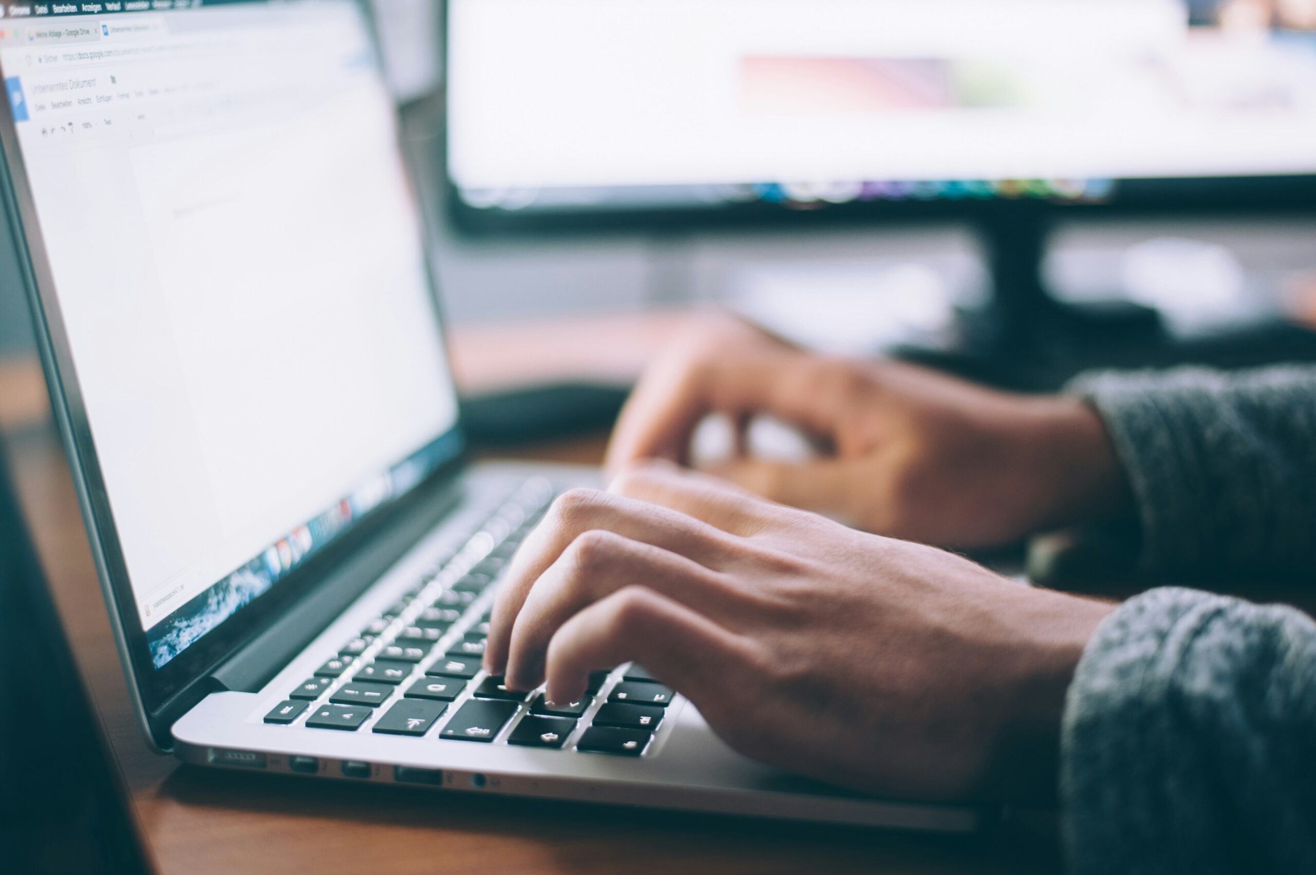 A person typing on a laptop computer.