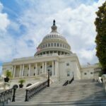Image of US Capitol in front of a blue sky with scattered clouds