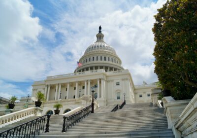 Image of US Capitol in front of a blue sky with scattered clouds