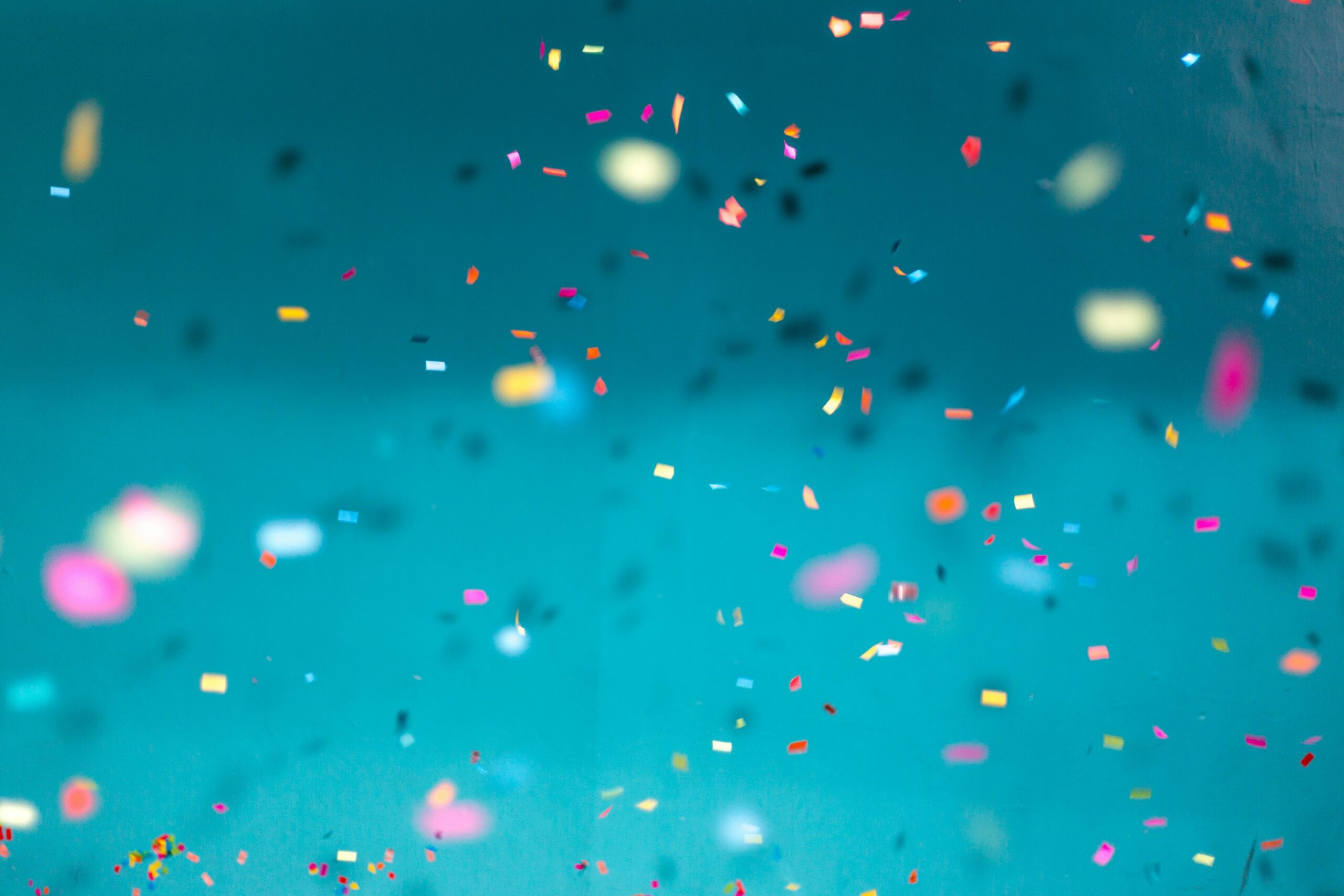 image of colorful confetti on a teal background