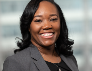 Dominique Rose smiling in a gray blazer