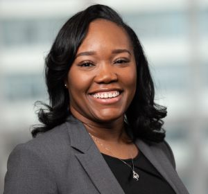 Dominique Rose smiling in a gray blazer