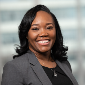 Dominique Rose smiling in a gray blazer